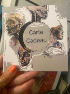 photo de la carte cadeau tenue par la main de l'Artiste